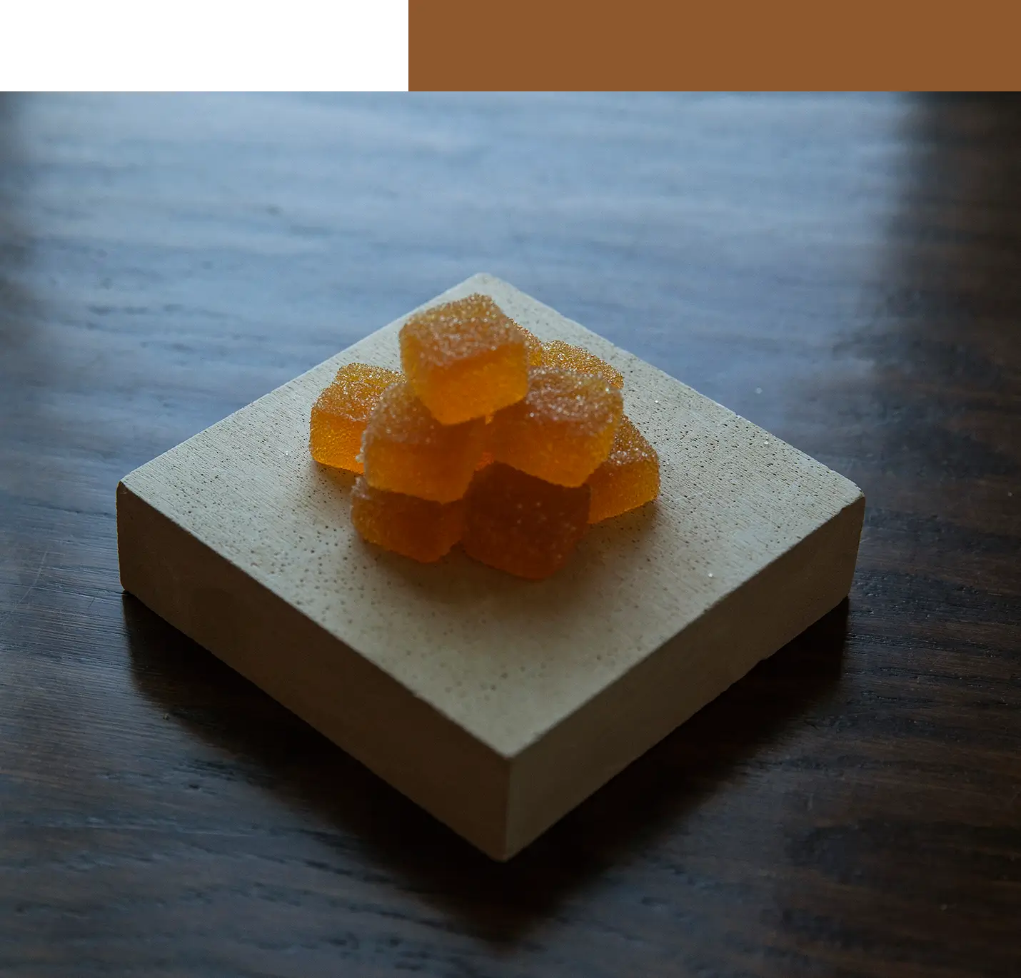 Sugar-coated amber jelly cubes on stone slab